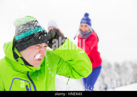 Junge Freunde, die Schneeball kämpfen Stockfoto