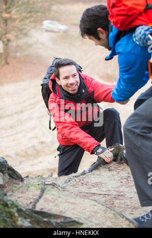 Wanderer, die helfen, Freund beim Wandern im Wald Stockfoto