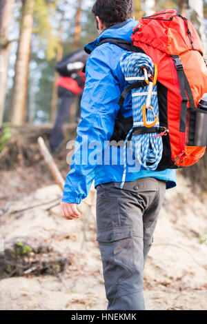 Rückansicht des männlichen Wanderer mit Rucksack stehend im Wald Stockfoto