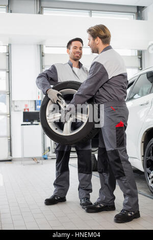 Gesamte Länge der Wartungstechniker tragen Reifen in Kfz-Werkstatt Stockfoto