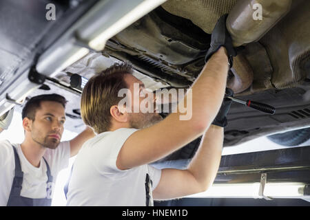 Männliche Reparatur Arbeiter Prüfung Auto in Werkstatt Stockfoto