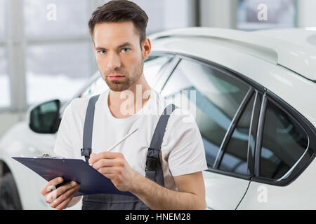 Porträt von zuversichtlich männlichen Instandhalter schreiben über Zwischenablage in Werkstatt Stockfoto