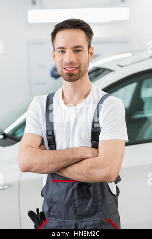 Porträt von zuversichtlich Wartung Ingenieur stehend Arme verschränkt in Werkstatt Stockfoto