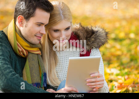 Paar mit digital-Tablette im Park im Herbst Stockfoto