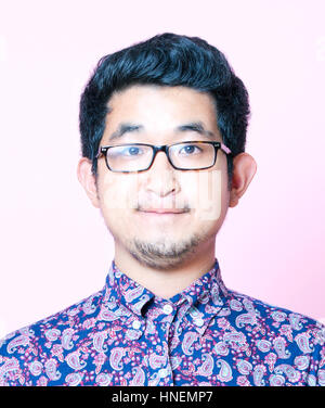 Geeky asiatischen Jüngling in buntes Hemd mit Brille Stockfoto