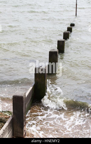 Welle trifft Strand Buhne Stockfoto