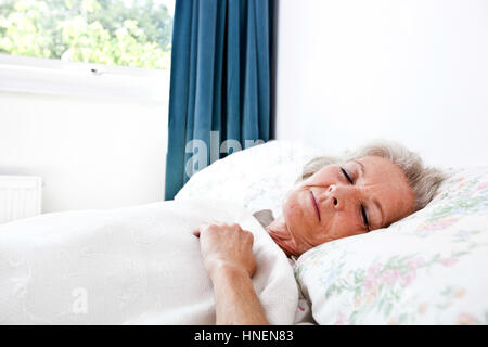 Ältere Frau schläft im Schlafzimmer zu Hause Stockfoto