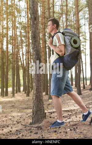Voller Länge Seitenansicht des männlichen Wanderer mit Rucksack wandern im Wald Stockfoto