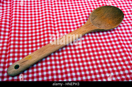 Holzlöffel hautnah auf einem roten und weißen Tischdecke Stockfoto