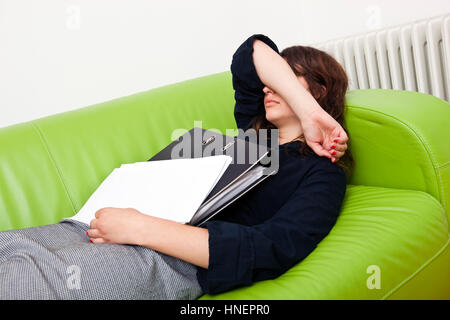 Geschäftsfrau, die auf einem Sofa schlafen Stockfoto