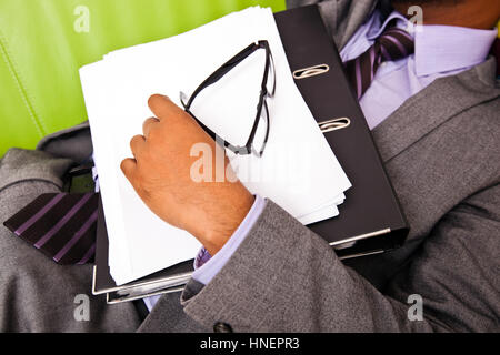 Nahaufnahme des Schlafens Unternehmenshilfe Hand hält Ordner Stockfoto