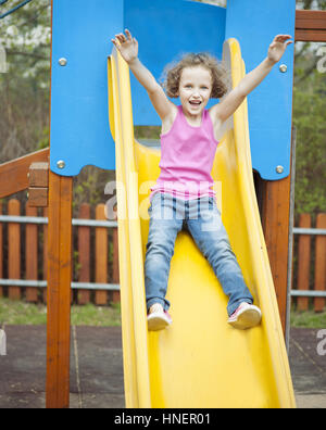 Junges Mädchen auf Folie auf Spielplatz Stockfoto