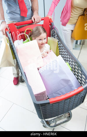 Nahaufnahme der jungen Tochter im Wagen geschoben von Vater und Mutter Stockfoto