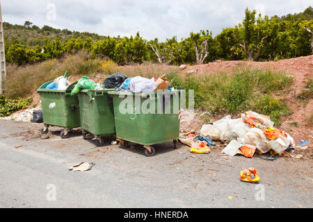 Überquellenden Mülltonnen neben Orange Obstgarten, Region Valencia, Spanien Stockfoto