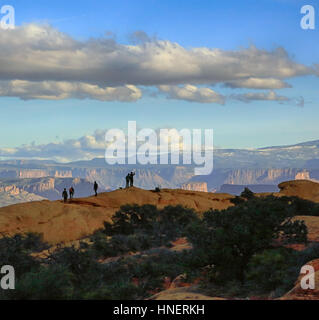 Die Silhouetten der Wanderer werden auf einer Felsformation im Arches National Park in Süd-Utah gesehen. Stockfoto