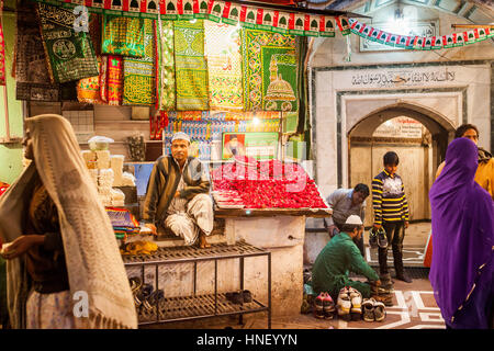 Verkäufer von religiöse Angebote, Souvenirs und Schrank für Schuhe, Eintritt ins Hazrat Nizamuddin Dargah, Delhi, Indien Stockfoto