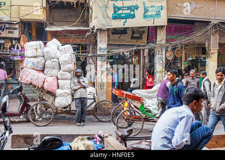 Träger, ausruhen und plaudern über Telefon in Nai Sarak Straße, in der Nähe von Chandni Chowk, Alt-Delhi, Indien Stockfoto