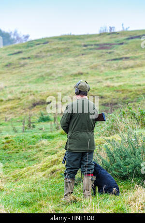 Ein Mann mit einem schwarzen Labrador Hund auf einem Tage schießen Stockfoto