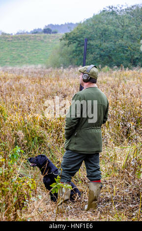 Ein Mann mit einem schwarzen Labrador Hund auf einem Tage schießen Stockfoto