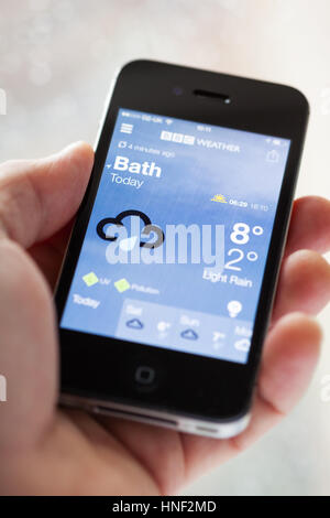 BATH, Großbritannien - 13. März 2015: Nahaufnahme der Hand, die ein Apple iPhone 4 s die Wettervorhersage auf die BBC Weather-Anwendung anzeigen. Geringe Bautiefe Stockfoto