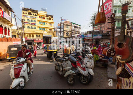 UDAIPUR, Indien - 16. Januar 2015: Beschäftigt Straßenszene in Jagdish Chowk, einem zentralen Stadtplatz in Udaipur mit Mopeds, Rikschas, einheimischen, Geschaeftsviertel gefüllt Stockfoto