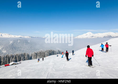 MORZINE, Frankreich - 7. Februar 2015: Skifahrer und Snowboarder auf der Piste La Combe in Morzine-Avoriaz Resort, Teil des Skigebietes Portes du Soleil. Stockfoto