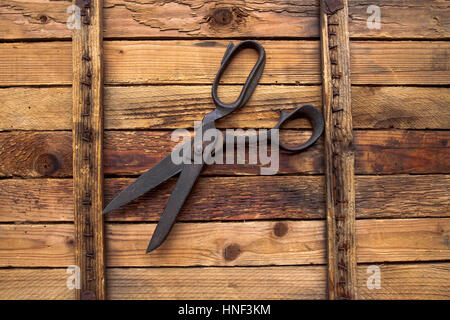 Alten Schere auf hölzernen Hintergrund, Vintage Hintergrund mit Nähwerkzeuge Stockfoto