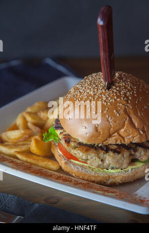 Chicken Burger hautnah mit Serviette und schwarzem Hintergrund Stockfoto