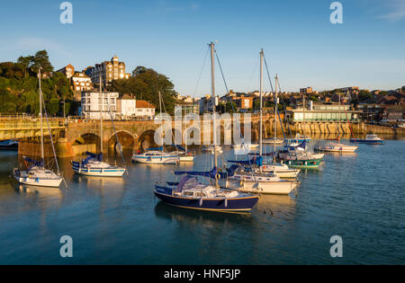 Angelboote/Fischerboote im Hafen von Folkestone, Kent mit dem Folkestone Harbour-Viadukt und Rocksalt Restaurant in Morgenlicht getaucht. Stockfoto