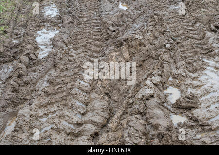 Dicke schlammigen Traktor reifen Titel in das Feld Eingang. Metapher Stick im Schlamm, matschigen Textur, schlammige Oberfläche, Schlamm, Winter Schlamm, sumpfigen Boden. Stockfoto
