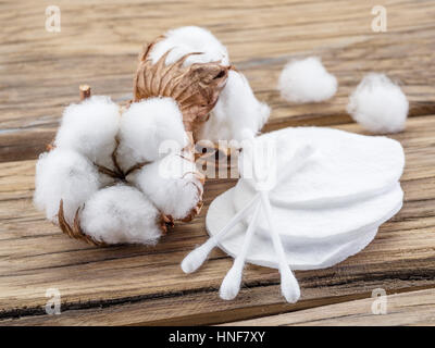 Flauschige Wattebausch und Wattestäbchen und Pads auf Holztisch. Stockfoto