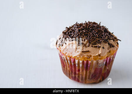 eine hausgemachte Schokolade Cupcake auf Tisch Stockfoto