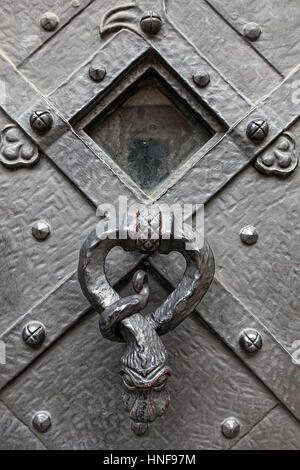 Alte historische Schmiedearbeiten, Metalltür von alten Kathedrale mit dekorativen Rapper, Klopfer. Architektur-Hintergrund. Stockfoto