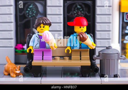 Tambow, Russische Föderation - 21. Januar 2017 Lego Mädchen und Jungen mit Ice creams sitzen auf der Bank im Lego-Straße. Rote Katze ist in der Nähe von Bank. Stockfoto