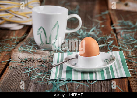 Gekochtes Ei zum Frühstück auf Ostern und Tasse Kaffee auf einem Holztisch Stockfoto