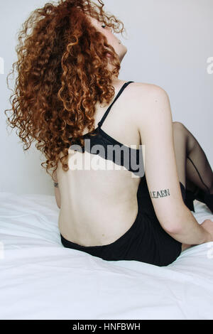 Porträt einer rothaarige junge Frau in ihrem Schlafzimmer Stockfoto