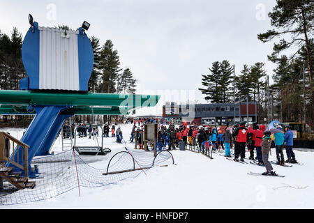 Aufstellung der Skifahrer wartet ein Skilift im Boler Mountain Ski Club in London, Ontario, Kanada. Stockfoto