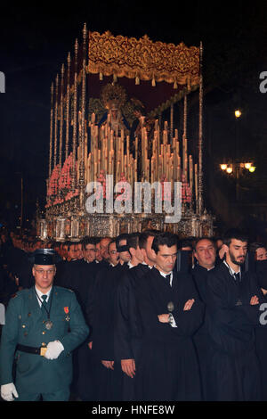 Eine christliche Bruderschaft, die mit einem Schwimmer während der Karwoche (Semana Santa) in Malaga, Spanien Stockfoto