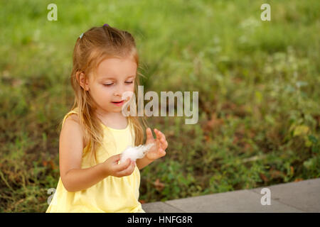 Niedliche kleine Mädchen essen Zuckerwatte. Ein Spaziergang im Sommerpark. Sommer-Urlaub. Outdoor-Aktivitäten. Stockfoto