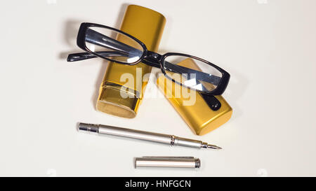 Die Gläser, Goldgehäuse und einen Stift. Weißen Hintergrund zu isolieren. Stockfoto