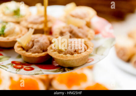 viele verschiedene Törtchen mit Pastete auf einem festlich gedeckten Tisch. Stockfoto