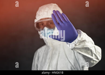 Medizinische Wissenschaftler tragen Schutzkleidung und Gestikulieren Stoppschild Glaswaren in Quarantäne Stockfoto