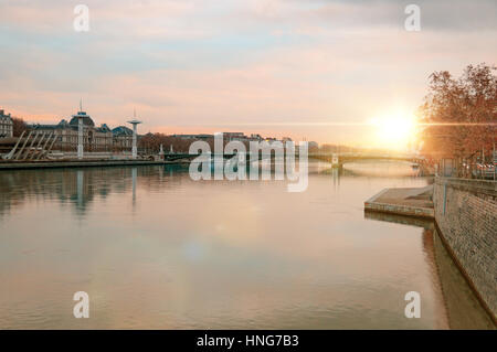 Blick auf die Rhone bei Sonnenuntergang im Winter mit der Brücke Universität im Hintergrund in Lyon Frankreich. Horizontale Komposition Stockfoto