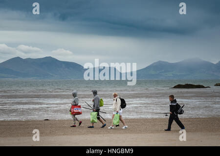 Familie kehrt Newborough Strand entlang aus einen Ausflug zum Fischen wie das Wetter schließt. Stockfoto