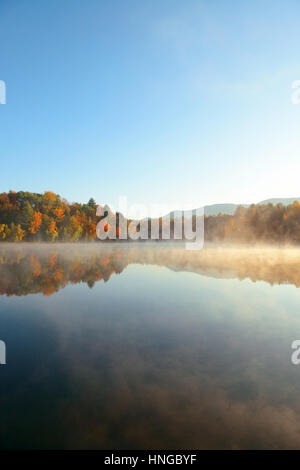 See-Nebel mit Herbstlaub und Bergen mit Reflexion in New England Stowe Stockfoto