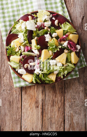 Gesunde Ernährung: Salat aus rote Beete, Ananas, Ziegenkäse und grünen Closeup auf einem Teller mischen. vertikale Ansicht von oben Stockfoto
