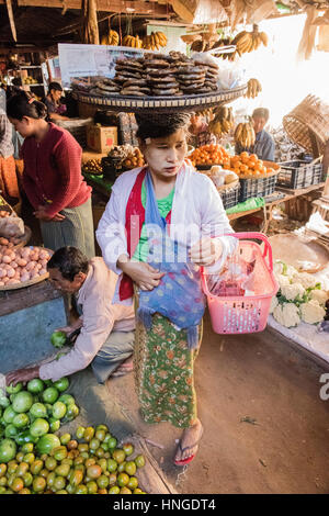 weiblichen Markt Händler Produkte auf ihrem Kopf in lokalen Kleid im Ausgleich Stockfoto