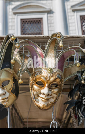 Nahaufnahme des venezianischen Karnevalsmasken mit schöne Dekoration auf dem Display für Verkauf im Freien vor dem Dogenpalast in Venedig, Italien. Stockfoto