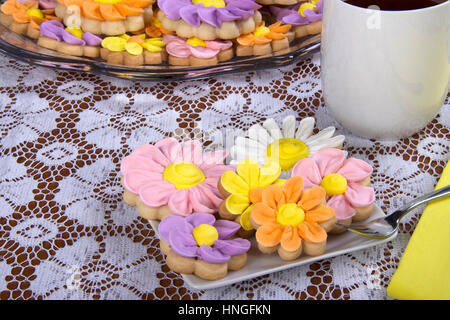 Schicke und elegante hausgemachte Frühlingsblumen sugar Cookies mit royal Icing, die Blütenblätter auf geleitet. auf einem Teller mit Getränk Ihrer Wahl, Kaffee oder Tee serviert. P Stockfoto