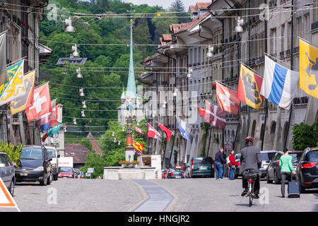 Kramgasse, Lebensmittelhändler Alley, Hauptstraße mit barocken Fassaden und Fahnen in der Altstadt von Bern, Schweiz Stockfoto